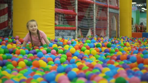 Девушка в бассейне с мячами — стоковое видео