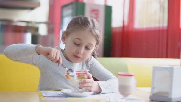 Girl eats dessert with a spoon — Stock Video