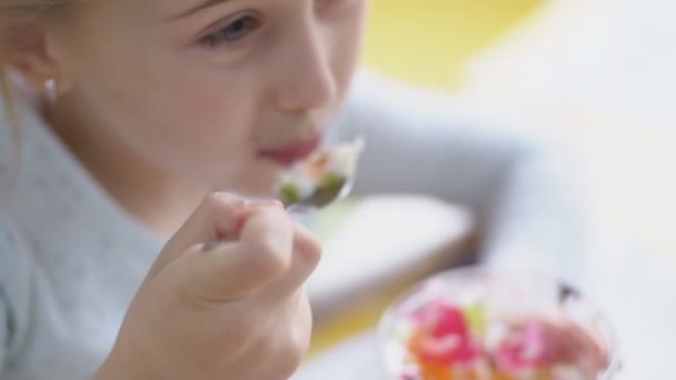 Девушка ест десерт ложкой — стоковое видео
