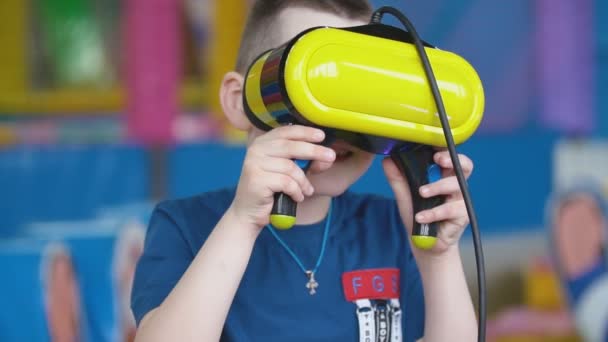 Little boy in a virtual reality helmet plays games — Stock Video