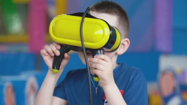 Little boy in a virtual reality helmet plays games — Stock Video