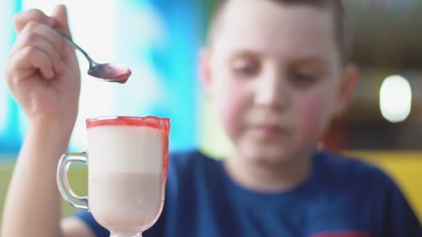Liten pojke i blå t-shirt äter dessert — Stockvideo