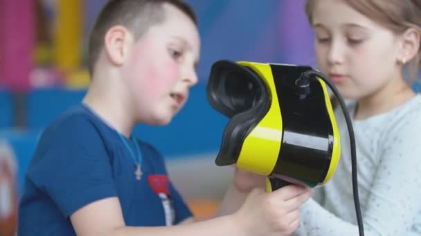 Little boy in a virtual reality helmet plays games — Stock Video