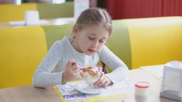 Κορίτσι τρώει το επιδόρπιο με ένα κουτάλι — Αρχείο Βίντεο