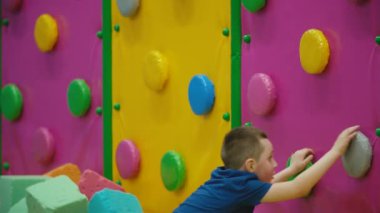 çocuk duvara tırmanıyor.