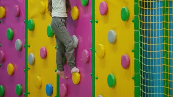 Flickan klättrar på klätter vägg — Stockvideo