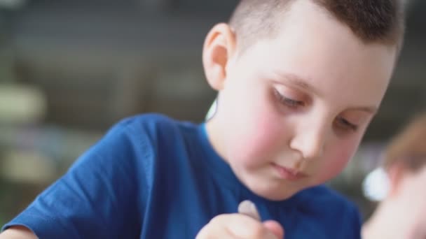 穿蓝色T恤的小男孩吃甜点 — 图库视频影像