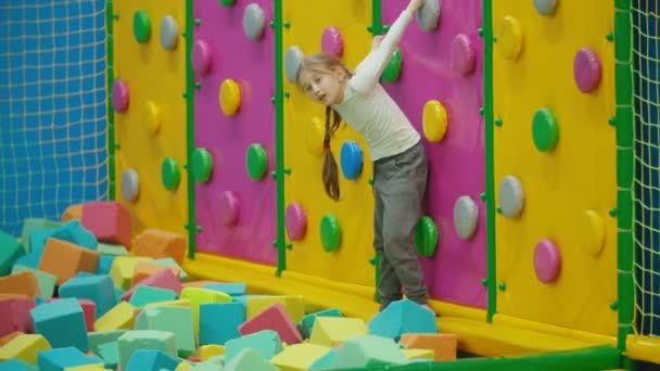 Dívka šplhá po horolezecké stěně — Stock video