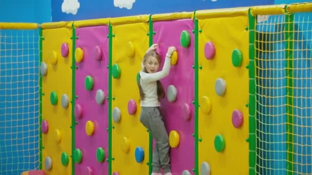 Dívka šplhá po horolezecké stěně — Stock video