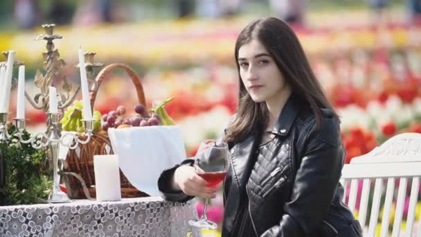 Chica bebiendo vino sentado a la mesa — Vídeos de Stock