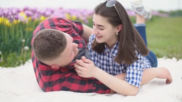 Jeune couple couché sur une couverture et parlant — Video