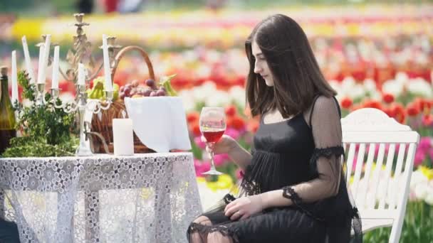 Chica bebiendo vino sentado a la mesa — Vídeos de Stock