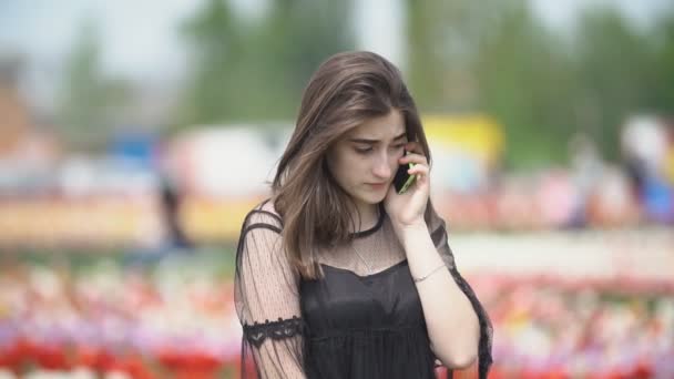 Meisje praten op de telefoon op het tulpen veld — Stockvideo