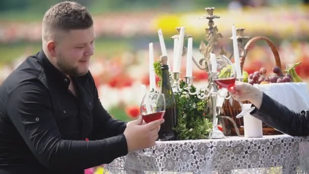 Junges Paar sitzt am Tisch und trinkt Wein — Stockvideo