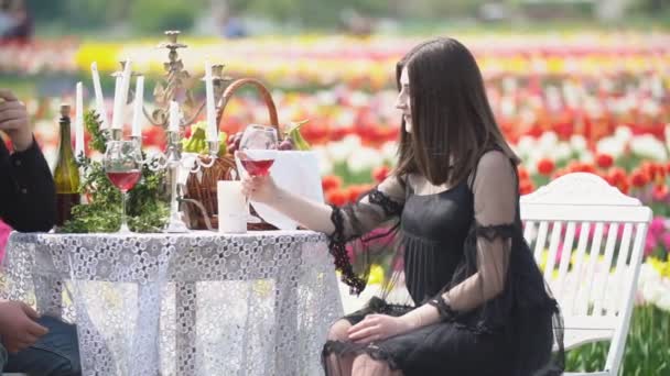 Chica bebiendo vino sentado a la mesa — Vídeos de Stock