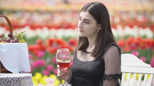 Lány iszik bort ül az asztalnál — Stock videók