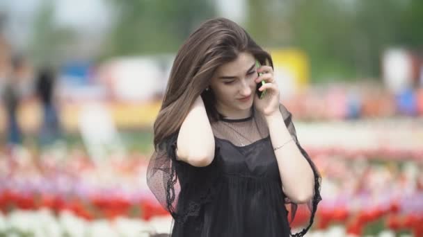 Menina falando no telefone no campo tulipa — Vídeo de Stock