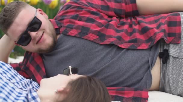 Νεαρό ζευγάρι ξαπλωμένο σε μια κουβέρτα — Αρχείο Βίντεο