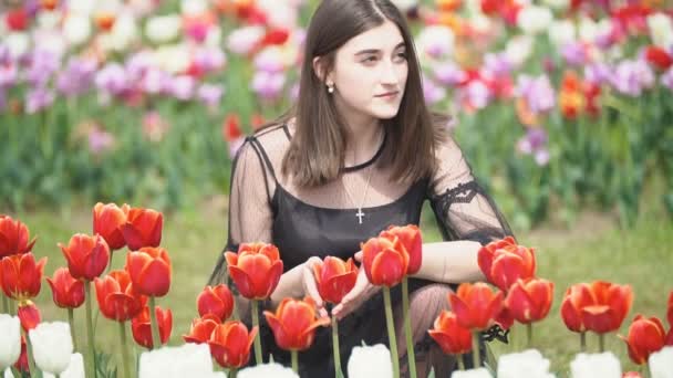 Menina cheirando tulipas vermelhas — Vídeo de Stock