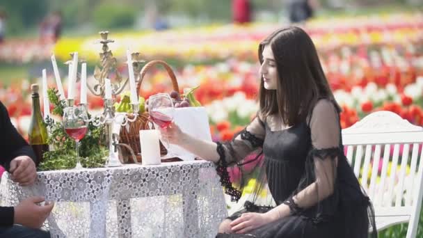 Chica bebiendo vino sentado a la mesa — Vídeos de Stock