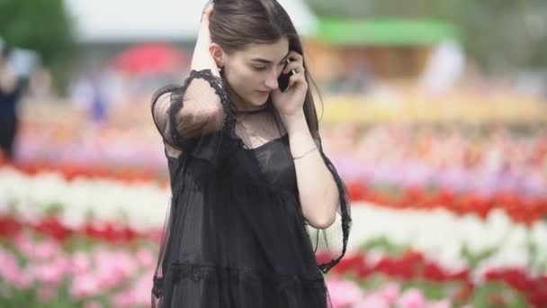 Menina falando no telefone no campo tulipa — Vídeo de Stock