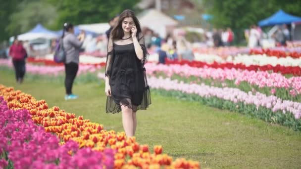 Meisje praten op de telefoon op het tulpen veld — Stockvideo