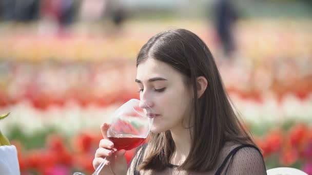 Chica bebiendo vino sentado a la mesa — Vídeos de Stock