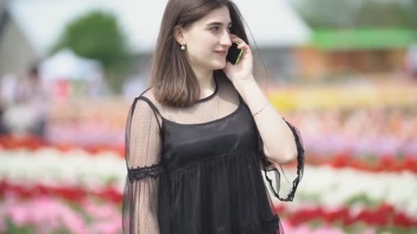 Ragazza che parla al telefono sul campo di tulipani — Video Stock