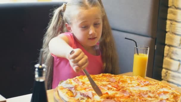 Klein meisje is snijden pizza — Stockvideo