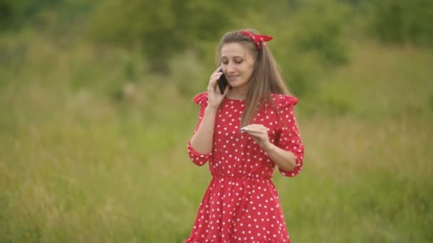 Chica en vestido rojo hablando por teléfono — Vídeos de Stock