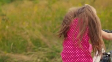 küçük kız içinde bir kırmızı takım sürme bir bisiklet