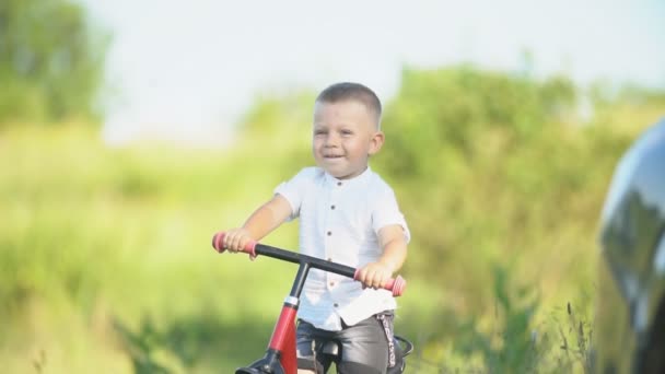 Un niño monta en bicicleta sin pedales — Vídeos de Stock