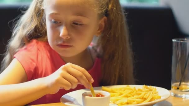 Κορίτσι τρώει πατάτες τηγανιτές — Αρχείο Βίντεο