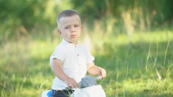 garçon assis sur un vélo en plastique 