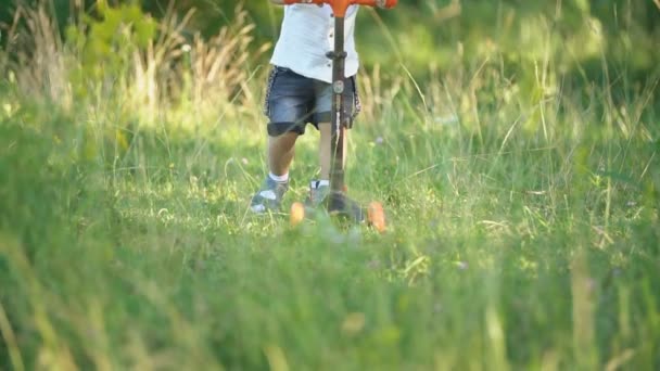 Jongen rijden een scooter — Stockvideo