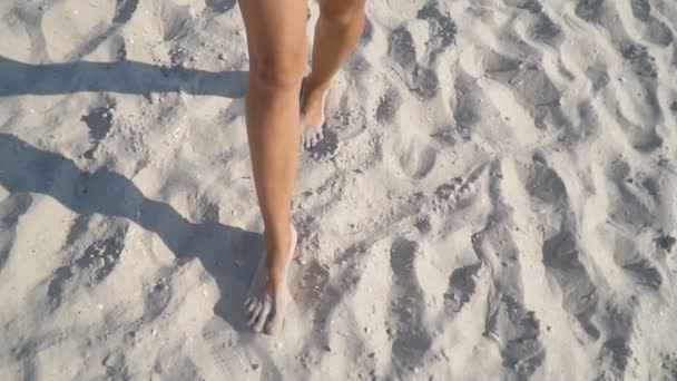 Ноги девушки, идущей по песку — стоковое видео