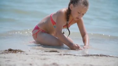 Kumsalda kumla oynayan kız.