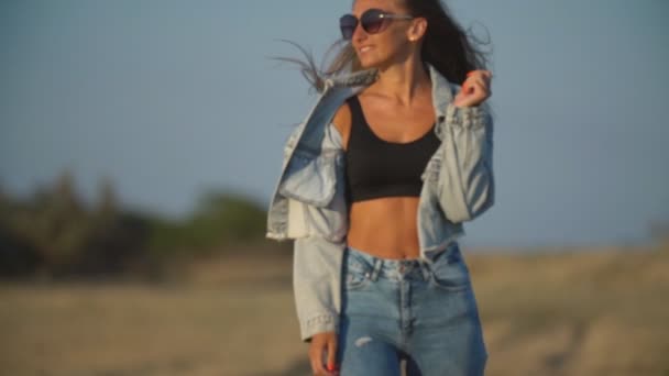 Девушка с длинными волосами в джинсах — стоковое видео