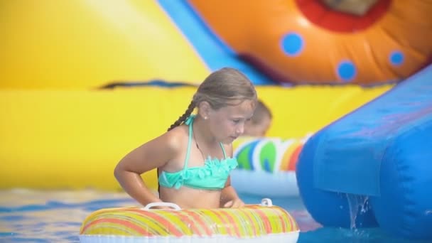 Girl climbs a slide in a water park — Stock Video