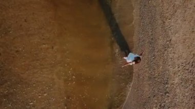 beyaz elbiseli kız plaj boyunca yürür