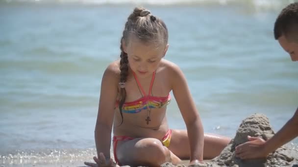 Дети строят замок из песка — стоковое видео