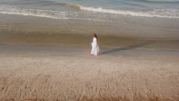 穿着白色连衣裙的女孩沿着海滩散步 — 图库视频影像