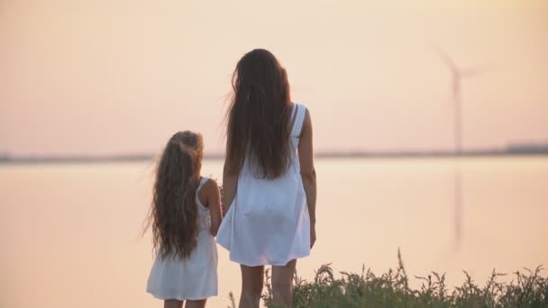 Mamá y su hija de pie en la orilla del mar — Vídeos de Stock