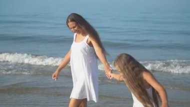 Anne ve kızı deniz kenarına gider.