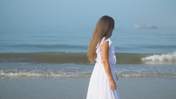 Mädchen in weißem Kleid geht am Meer entlang — Stockvideo