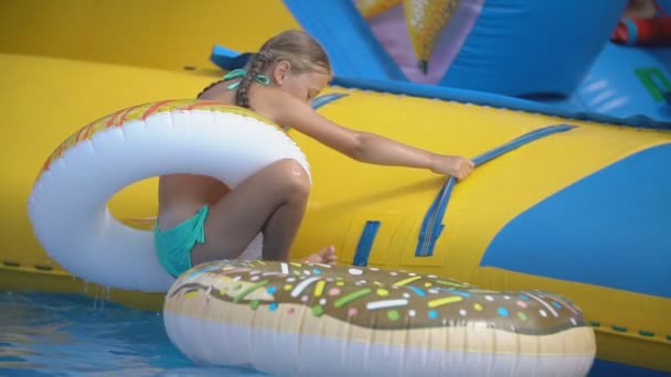 Menina sobe um slide em um parque aquático — Vídeo de Stock