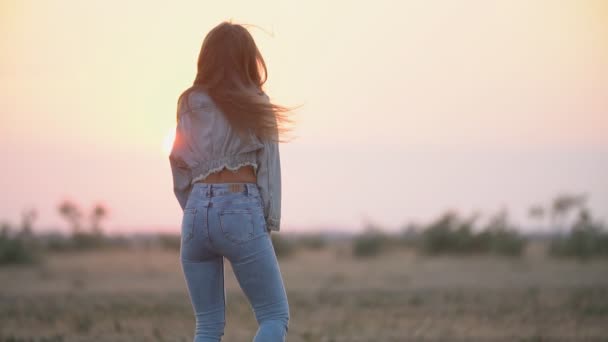 女孩穿着牛仔裤对抗夕阳天空 — 图库视频影像