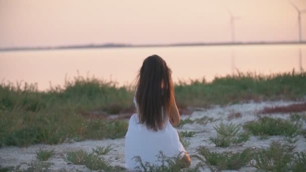 Mutter und Tochter sitzen am Strand und schauen in die Ferne — Stockvideo