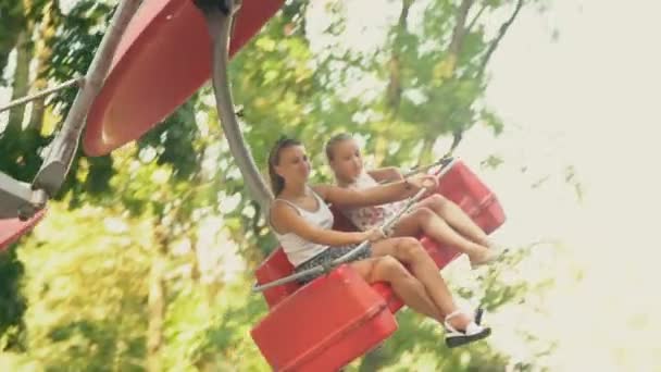 Moeder en dochter rijden op een carrousel — Stockvideo