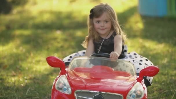 Barn rider en röd bil — Stockvideo